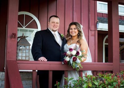 Bride and groom pose for photo in outdoor barn setting, a lovely wedding venue
