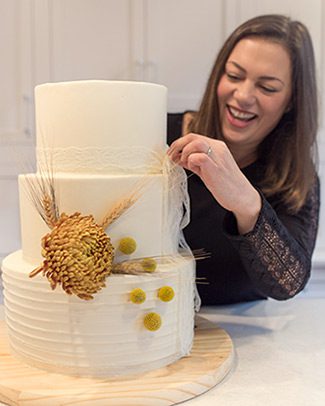 A novice baker puts the finishing touches on her friend's wedding cake