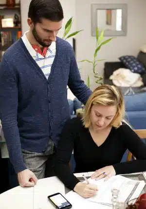 An engaged couple looks over their wedding budget at home