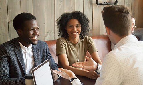 An engaged couple meets with an insurance specialist to obtain event insurance for their wedding