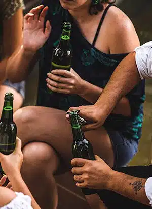 young man using one of our unique wedding favor ideas, a bottle opener, to open beer while at a friend's wedding