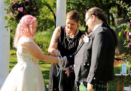 A bride and groom participate in a traditional unity ceremony called handfasting. Photo by Darling Photography