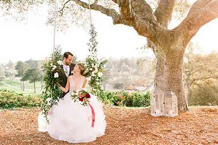 Photo of a groom with bride in a swing by Dejoy Photography