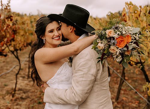 Bride and groom embrace at the Rough & Ready Vineyards. photo by Lela Spiva Photography