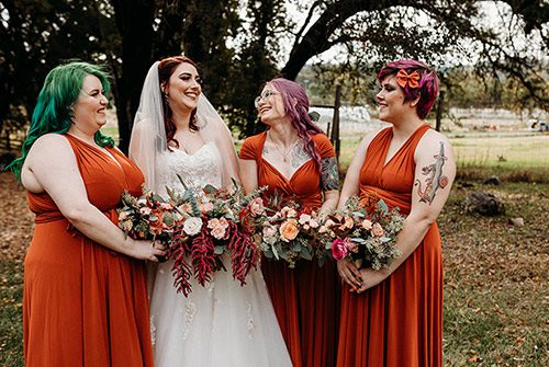 A bride shares a laugh with her bridesmaids at her fall wedding. Photo by Rebekah Townley Photography