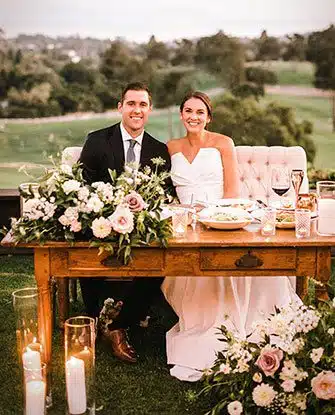 A groom and bride seated at their table for the reception