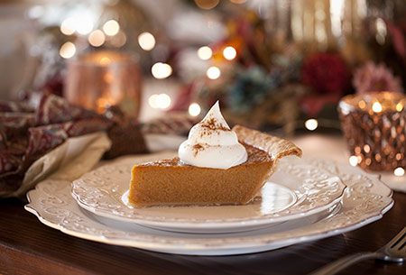 Piece of pumpkin pie with whipped cream dollop on top