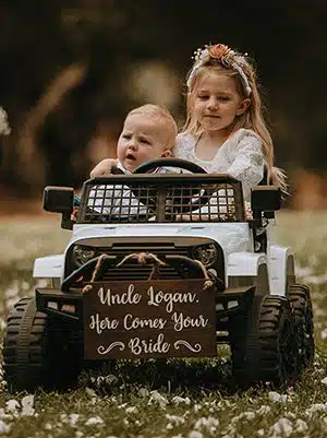 A young ring bearer and flower girl make their way down the aisle in a toy Jeep. Photo by Ashton Imagery