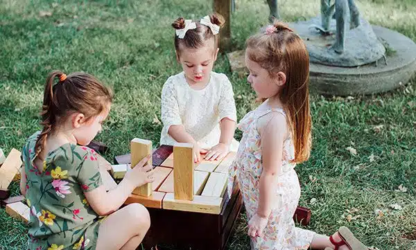 Three young girls playing Jenga together at a Rough & Ready Vineyards wedding reception. Photo by Athena Kalindi