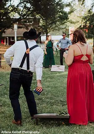 Wedding guests play cornhole. Photo by Athena Kalindi Photography