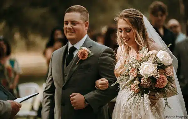 A groom and bride link arms during their spring wedding ceremony. Photo by Ashton Imagery