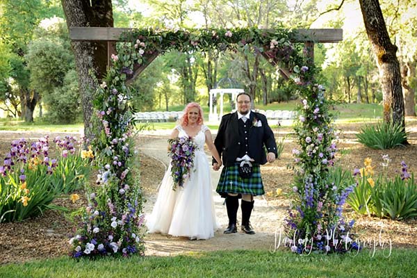 Bride and groom grand entrance at wooden arch