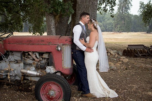 Couple by tractor field in background