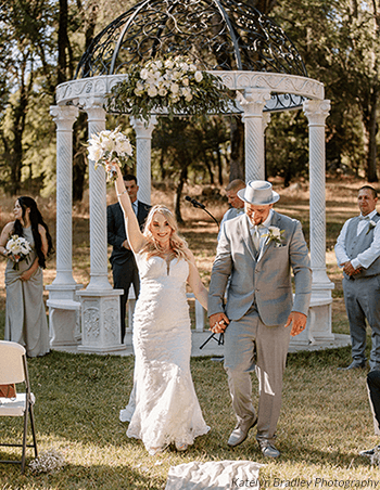 Bride celebrates as she walks down the aisle as a married woman. Photo by Katelyn Bradley Photography