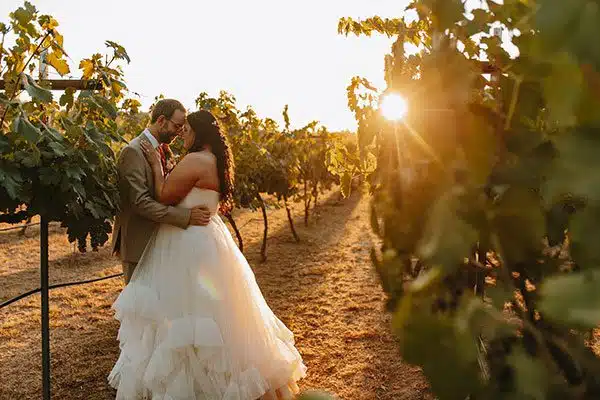 bride and groom share a kiss in the beautiful vineyard