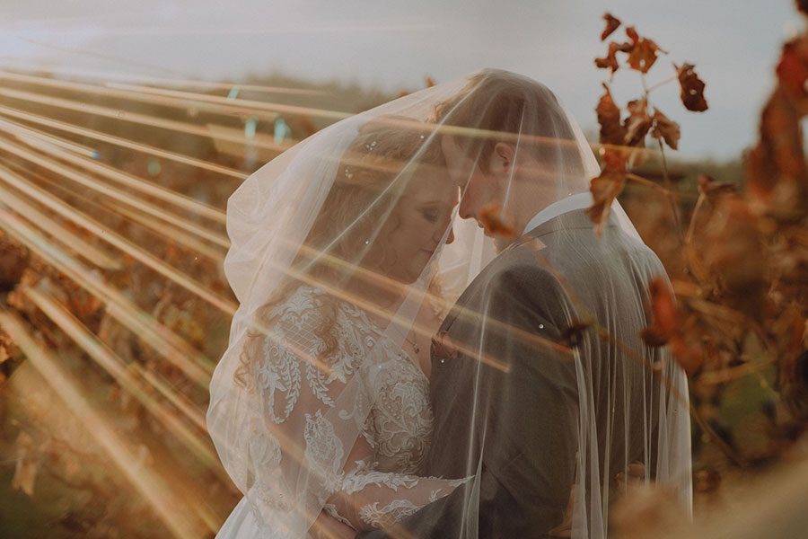 Featured wedding couple Shelby and Bennett share an intimate moment under bride's veil