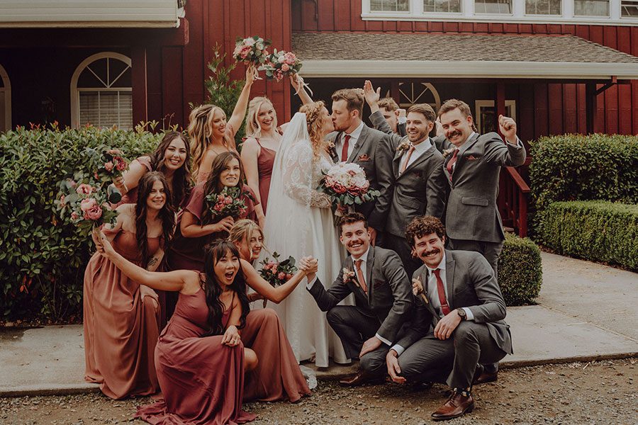 Wedding party poses for a photo in front of Rough and Ready Vineyards lodge