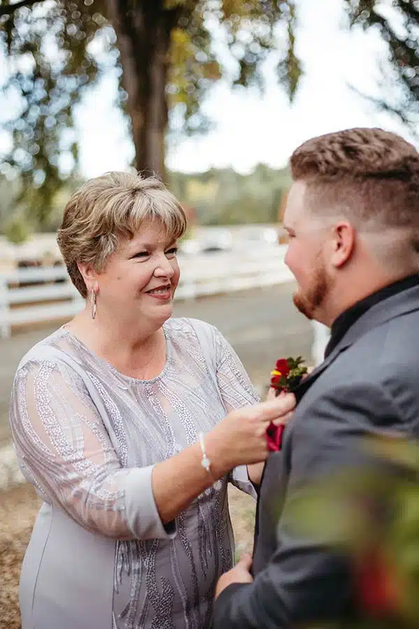 mom-nj The groom's mother helps him with his boutonnière