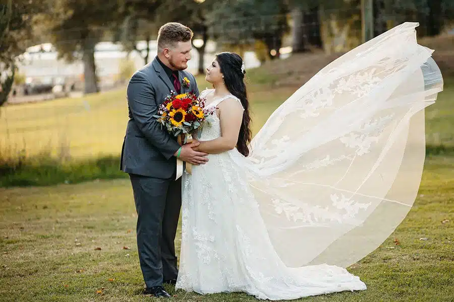 wind-nj James and Natalie smile at each other as the wind blows up the bride's train