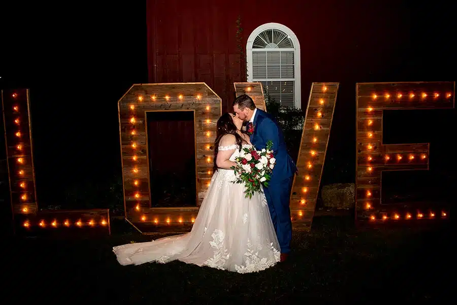 Brooke and Brandon kiss by marquee letters that spell love