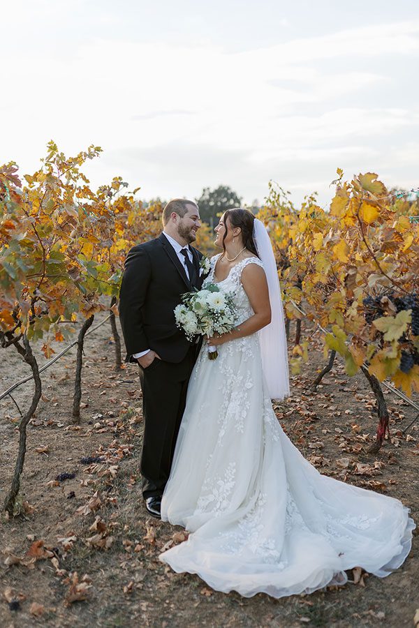 Featured Wedding couple stand together in the vineyards