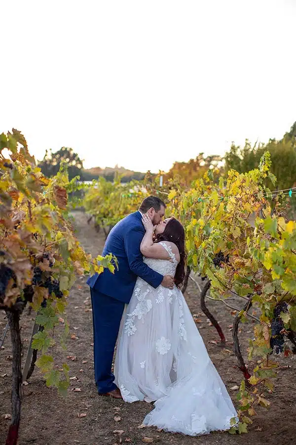 Brandon and Brooke kiss in the Rough & Ready Vineyards