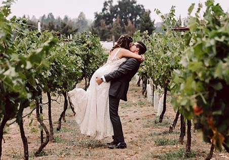 Shawna and Lucas embrace in the vineyard. Photo by Mindful Media Photography