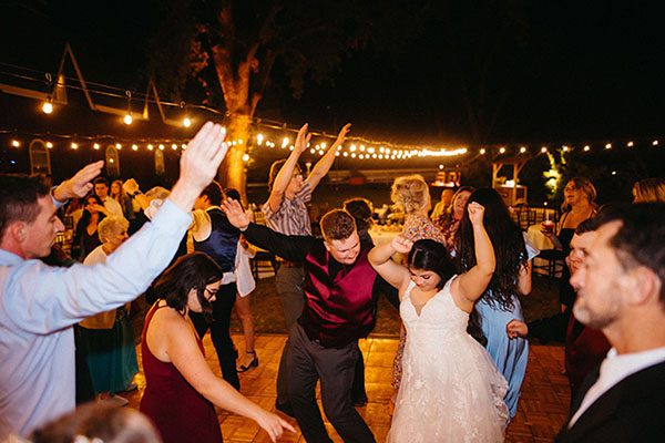 A bride and groom having fun on the dance floor with their guests. Photo by Bryan Gallagher Photography