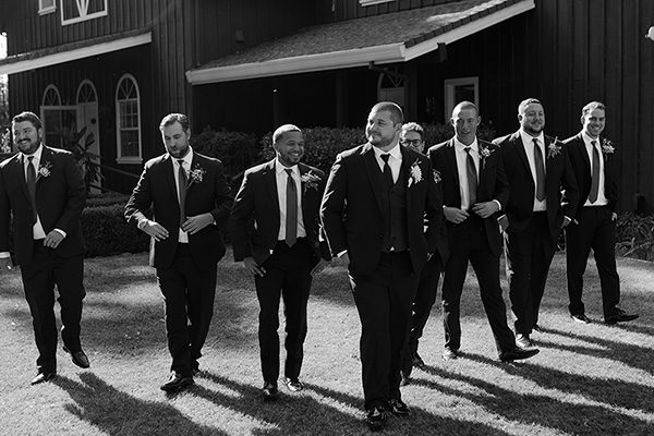 Groomsmen walking in front of the guesthouse. Photo by Elizabeth Jane Photography