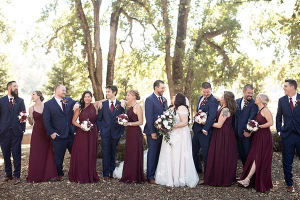 Casual group photo of a wedding party near oak trees. Photo by A Moment of Joy Photography