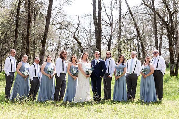 Wedding party posed under heritage oaks. Photo by Andrew and Melanie Photography