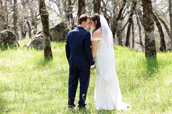 Bride and groom kissing under oak trees. Photo by Andrew and Melanie Photography