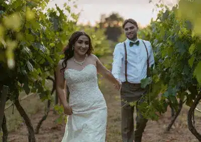 Bride leads her groom through the vineyards at sunset. Photo by Heidi Peinthor Photography