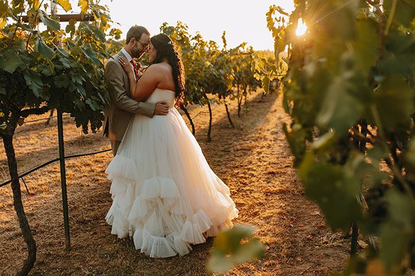Bride and groom share a tender moment at sunset in the vineyards. Photo by Ashton Imagery