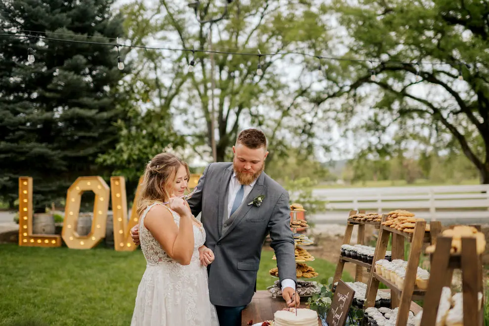 Danielle and Tim serve each other cake at their April wedding