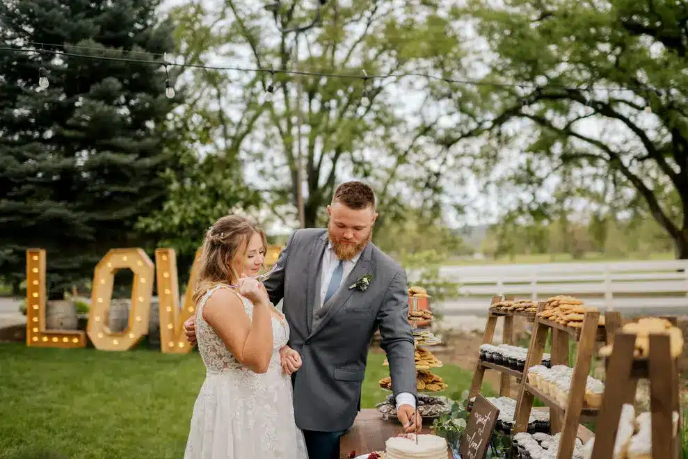 7174-danielle-tim Danielle and Tim serve each other cake at their April wedding
