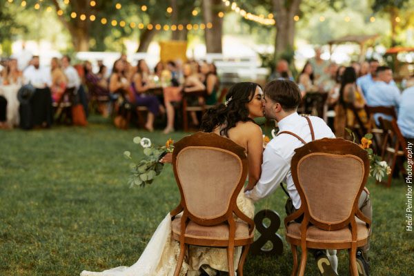 Bride and groom kissing at their reception after planning their wedding in northern California. Photo by Heidi Peinthor Photography