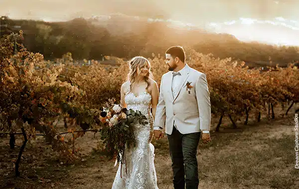 Bride and groom leisurely stroll the Rough & Ready Vineyards. Photo by Dream Capture Studios.