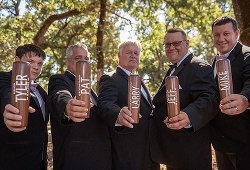 Groomsmen showing off the custom drinkware they received as wedding party gifts