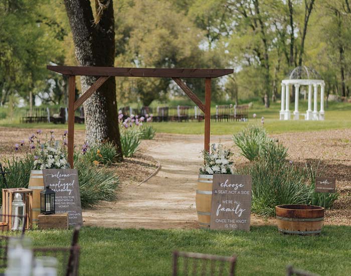 wooden wedding arch on pathway to gazebo