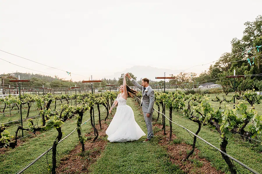 KNVineyardDance_2025-05-03-191841-640A7766 groom twirls bride in the vineyards