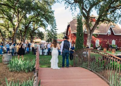 Couple walking across bridge to reception. Kelle Pickell Photography