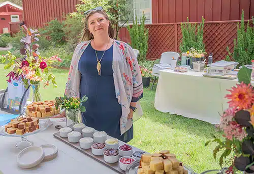 Emily of Emily's Catering and Cakes smiles from her booth at a bridal fair