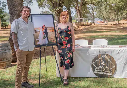 Dream Capture Photography's team smile from their booth at a bridal fair