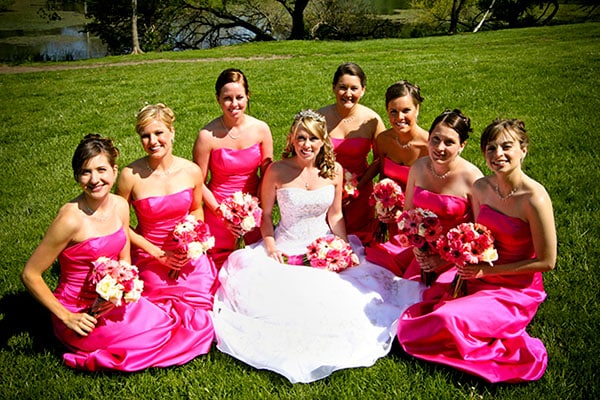 A happy bride back in 2008 surrounded by her bridesmaids wearing one of the outdated wedding traditions, identical dresses