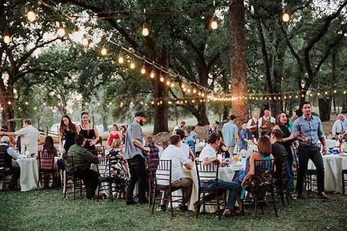 Wedding guests at a reception leaving their tables to get food from the buffet
