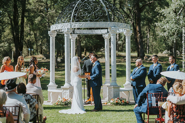 Happy couple exchanging vows by the gazebo after choosing a wedding venue at Rough & Ready Vineyards